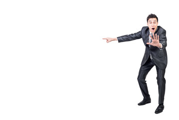 Shocked man in suit pointing aside. White background.