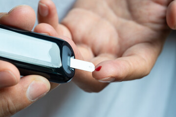 hand of people check diabetes and high blood glucose monitor with digital pressure gauge. Healthcare and Medical concept	