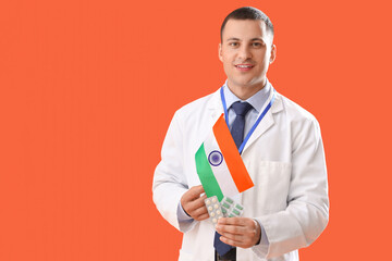 Male physician with flag of India on orange background. National Doctor's Day celebration