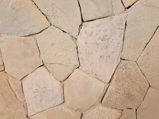 Beige cream flagstone or limestone slab random cut on a floor and wall. Seamless natural beige stone background texture.