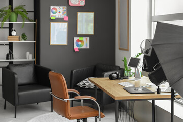 Photographer workplace with photo camera, color wheel charts and lighting equipment in modern studio