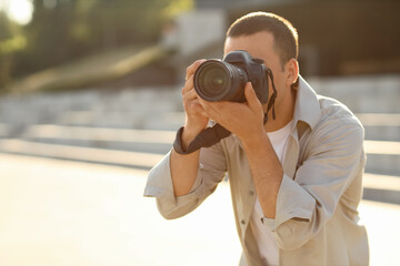 Male photographer with modern camera outdoors