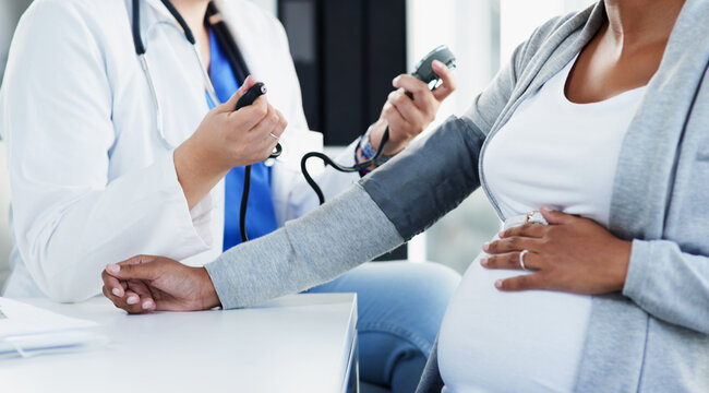 Hospital, pregnant woman and doctor with appointment for blood pressure, monitor heart rate and checkup. Healthcare, patient and obstetrician with consultation for pregnancy, hypertension or wellness
