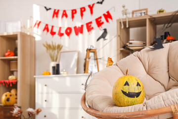 Halloween pumpkin on armchair in living room, closeup