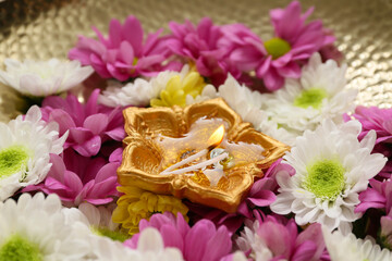 Plate with diya lamp and flowers, closeup. Divaly celebration