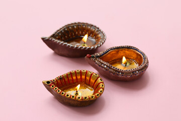 Diya lamps on pink background. Divaly celebration