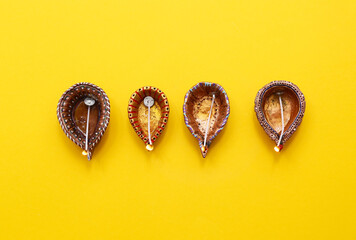 Diya lamps on yellow background. Divaly celebration