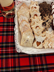 Sardinian Pastries on a Lace Paper atop a Red Plaid Christmas Tablecloth. Vertical Flat Lay