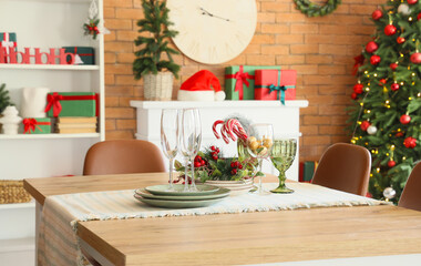 Dishes with Christmas decor on dining table in room