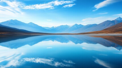 Calm blue water in a lake, reflections of mountains,