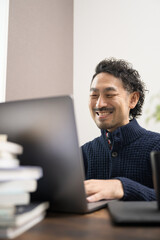 オンラインで勉強する男性　カメラ目線の笑顔秋冬