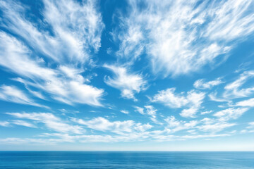 Fototapeta premium White cirrus clouds on blue sky over ocean horizon
