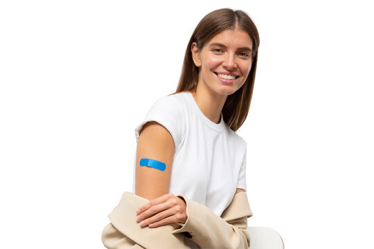 Portrait of happy vaccinated female smiling after getting vaccine shot. Woman holding down her sleeve to show her arm with blue bandage after vaccination