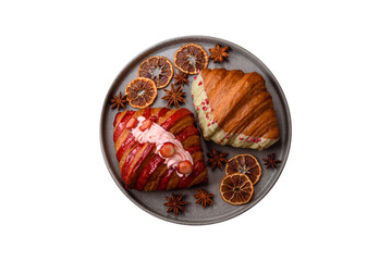 Fototapeta premium Crispy sweet red croissant with pistachio, raspberry and strawberry