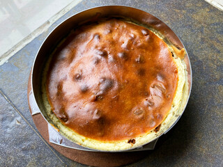 A freshly baked Basque cheesecake features a rich, creamy center with a beautifully caramelized, slightly burnt brown top.