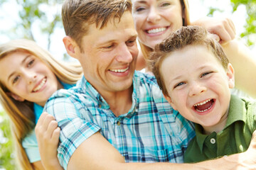 Fototapeta premium Portrait, family and bonding with hug, love and parents with children, outdoor and embrace in nature. Happy, woman and man with kids, together and relax in weekend, fun and break in park and youth