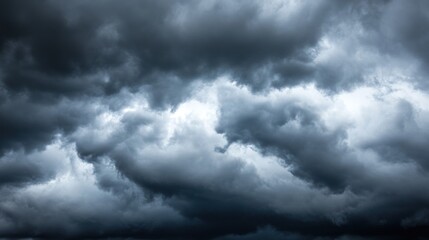 Obraz premium Thick layers of dark, swirling clouds fill the sky, creating a foreboding atmosphere as evening approaches, hinting at a heavy rainstorm