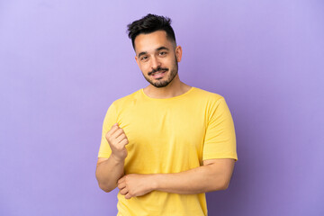 Young caucasian man isolated on purple background laughing
