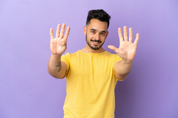 Young caucasian man isolated on purple background counting nine with fingers