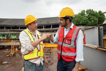 Asia engineer man worker fist bump with India engineer man with crane background 