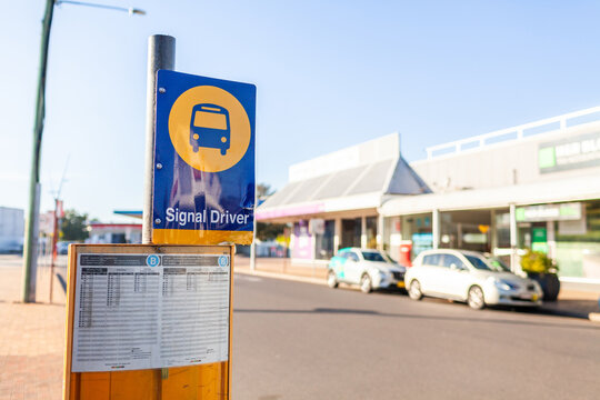 Signal driver bus route sign and timetable beside road downtown