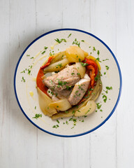 Baked mackerel with escalivada vegetables, peppers, onions and eggplant. Top view table with decoration.