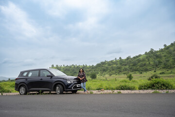 Young indian woman happy in front of her car