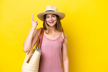 Young caucasian woman holding a beach bag isolated on yellow background pointing up a great idea