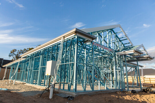 blue frame of a house under construction on a sunny day