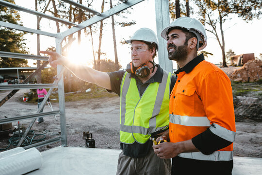 Construction workers looking and talking at the construction site.