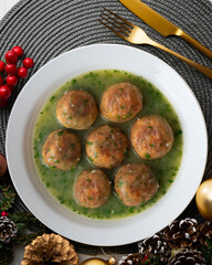 Fish meatballs with green parsley sauce. Top view table with Christmas decoration.
