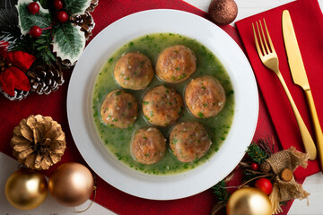 Fish meatballs with green parsley sauce. Top view table with Christmas decoration.