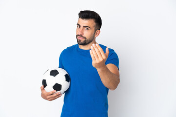 Handsome young football player man over isolated wall inviting to come with hand. Happy that you came