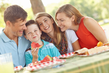 Family, happy or love in nature for picnic, excited and watermelon for healthy snack. Parents, kids portrait and favorite fruit in park with smile, playful and support on summer vacation in Australia