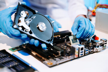 Obraz premium Technician repairing inside of hard disk drive by screwdriver. the concept of data, hardware, technician