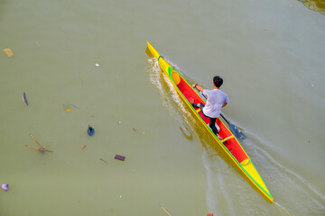 a man rowing a canoe on a river.