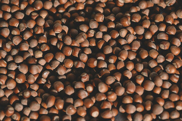 Hazelnuts in a wooden bowl on rustic background, Hazelnut background with green leaf