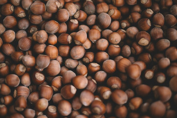 Hazelnuts in a wooden bowl on rustic background, Hazelnut background with green leaf