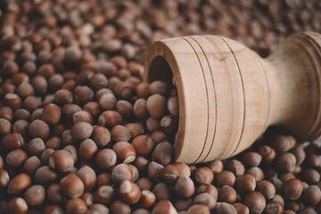 Hazelnuts in a wooden bowl on rustic background, Hazelnut background with green leaf