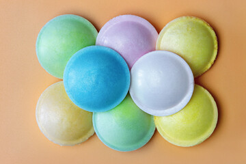 A bright assortment of colorful candies in various pastel shades on a peach background