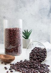 Glass jars with purple organic beans on light kitchen table.Macro.