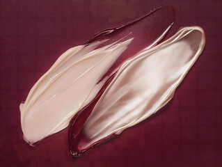 Close-Up of Two Swatches of Clear Gel on a Burgundy Background