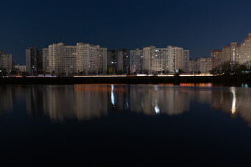Fototapeta premium Night Skyline with lights on the evening lake, Kyiv, Ukraine