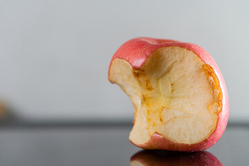 Bitten Red Apple on Reflective Surface