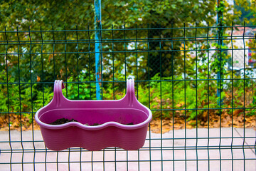 Garden pots. Flower pots hung on iron railings.