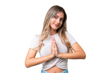 Fototapeta premium Young Uruguayan woman over isolated background keeps palm together. Person asks for something