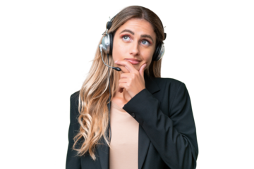 Telemarketer pretty Uruguayan woman working with a headset over isolated background having doubts and with confuse face expression