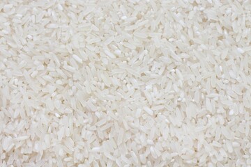 Dry Uncooked White Rice Background - Top View, Flat Lay. Scattered Raw Long Grain Rice. Asian Cuisine and Culture. Healthy Eating Ingredients. Diet Food