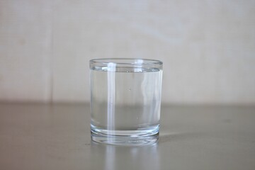 Glass with clear water on table in kitchen, space for text