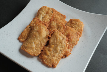 crispy flour fried tempeh which is served on a plate.